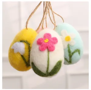 Detailed macro view of handmade wool felt Easter eggs featuring colorful floral patterns