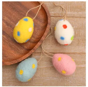 Detailed macro view of colorful felted wool Easter eggs with hanging jute strings