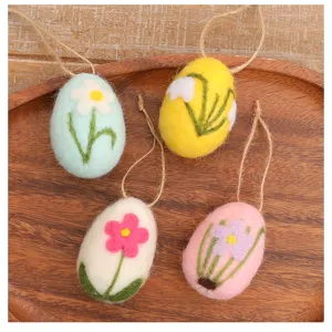 Detailed view of four handmade wool felt Easter egg ornaments with floral patterns