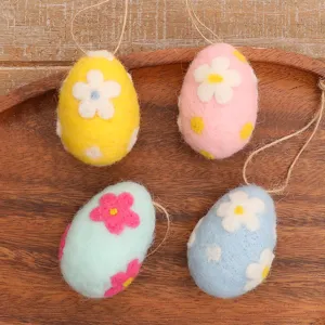 Four colorful handmade wool felt Easter eggs with floral patterns and rustic hanging strings.