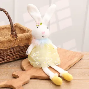 Cuddly white Easter bunny plush doll wearing a yellow floral daisy dress on wooden board