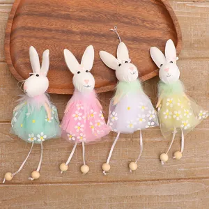Set of four colorful Easter bunny fabric pendants with floral dresses on a wooden tray