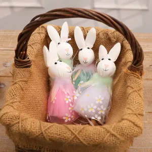 Four cute cloth Easter bunny pendants in floral dresses placed inside a rustic wicker basket