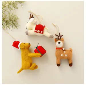 Detalle de tres adornos de fieltro de animales navideños hechos a mano con lazos para colgar