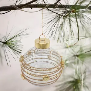 Primer plano de una bola de Navidad transparente con rayas doradas de purpurina