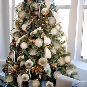 Vista detallada de bolas de Navidad pintadas en oro champán y transparentes en el árbol