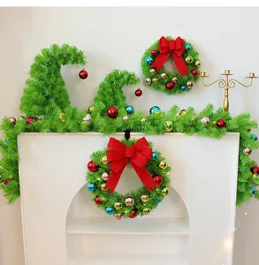 Vue détaillée de couronnes de Noël vertes et de décorations d'arbres sur une cheminée