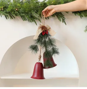 Gedetailleerde weergave van rode kerstbel ornamenten met dennennaalden en jute strik