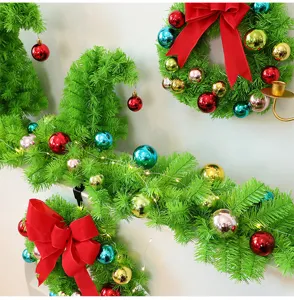 Détail de couronnes de Noël vertes avec ornements colorés et nœuds rouges décoratifs