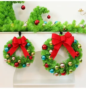 Détail de couronnes de Noël vertes avec de grands nœuds rouges et des boules colorées