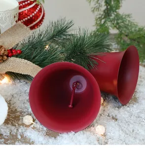 Close-up van rode matfluwelen kerstklokken in een decor van sneeuw en dennentakken