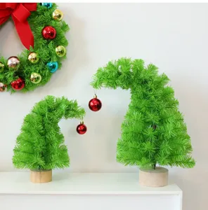 Détail de deux mini sapins de Noël à col tordu avec des boules rouges sur une étagère