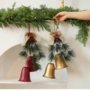 Rustieke kerstbelhangers met dennennaalden en jute strikken op een schouw van de haard