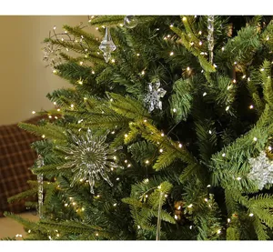 Close-up detail of clear crystal snowflake and icicle ornaments on a lit green Christmas tree