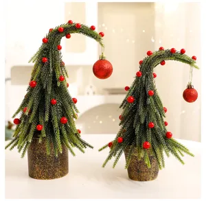 Detail of two mini artificial bent Christmas trees with red balls in textured pots