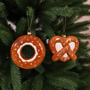 Gingerbread donut and pretzel Christmas ornaments hanging on a festive pine tree