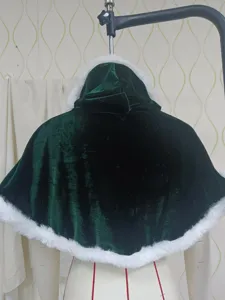 Detalle de capa navideña de terciopelo verde, ribete de piel sintética blanca para fiestas.