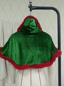 Detalle de capa navideña de terciopelo verde con capucha, suave ribete de pelo sintético rojo.