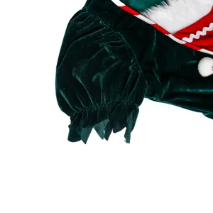 Détail de manche de costume de Noël en velours vert avec bordure peluche et pompon.