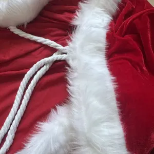 Vista dettagliata del tessuto della cappa di Natale in velluto rosso con bordo in pelliccia.