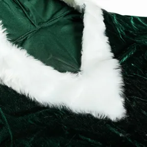 Close-up detail of green velvet fabric and soft white faux fur trim for holiday costume.