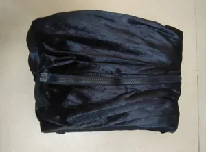 Dettaglio costume nero con tessuto morbido e cerniera centrale per abbigliamento.