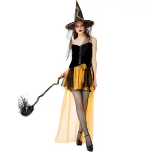 Détail du costume de sorcière d'Halloween avec robe en maille, chapeau et balai accessoire.