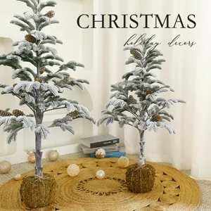 Two artificial snow-dusted Christmas trees with pine cones and moss bases