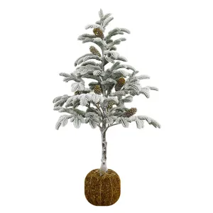 Snow-dusted artificial Christmas tree with natural pinecones and moss-covered base