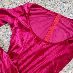 Close-up van roze fluwelen stof, ronde halslijn en ritssluiting detail voor kleding.