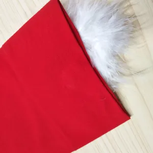Primo piano di tessuto rosso e finitura soffice bianca per i dettagli natalizi festivi.