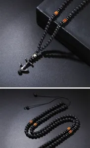 Detail view of men's lava stone necklace featuring a vintage metal ship anchor pendant