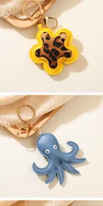 Detail view of blue leather octopus and leopard print flower keychains in gold finish