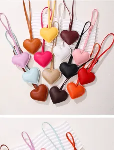 Close-up showing a variety of colorful heart-shaped PU leather bag charms with matching straps.