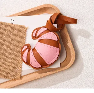 Close-up van een roze en bruine PU-lederen croissant tasbedel op een houten dienblad