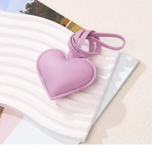 Detailed view of a purple PU leather heart pendant resting on a decorative wavy white tray.