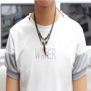 Detail of retro ethnic style men's necklace with tusk pendant worn by model