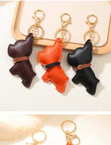 Vista dettagliata di tre portachiavi in pelle Bulldog francese marrone, arancio e nero