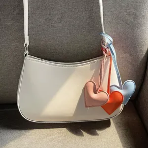 Cute minimalist heart-shaped PU leather charms attached to a white stylish shoulder bag