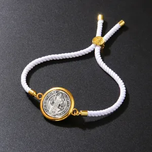 Close-up detail of a vintage white cotton rope bracelet with an adjustable golden coin pendant