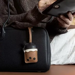 Handmade PU leather bubble tea bag charm accessory shown on a black leather handbag