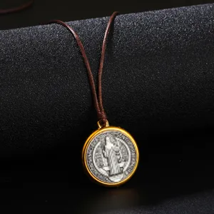 Macro shot of a vintage gold-plated round medal pendant with brown adjustable cord