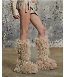 Détail de bottes punk en fausse fourrure beige avec sangles à boucles et rivets