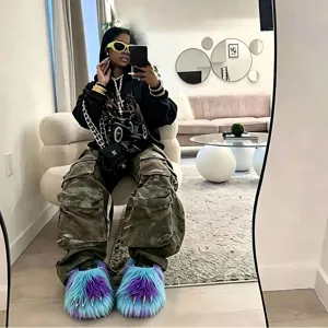 Fluffy blue and purple monster claw slippers with metallic nails shown on a model