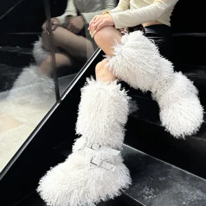 Gros plan de bottes blanches en fausse fourrure avec brides à boucles cloutées punk