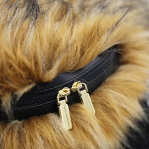 Detailed macro view showing gold-toned double zippers on fluffy faux raccoon fur backpack