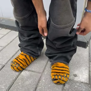 Detail of fuzzy tiger print claw slippers with silver metal nails and platform sole.