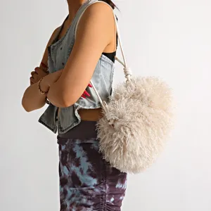 Detailed view of a soft plush faux beach sheep wool cloud bag worn over the shoulder.