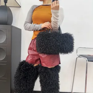 Modella con borsa tote in finta pelliccia nera e scaldamuscoli abbinati in stile chic