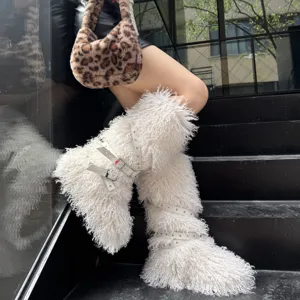 Détail de bottes blanches en fausse fourrure avec des boucles et des rivets punk.